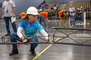 A member of the Florida Gulf Coast University steel bridge team works to assemble their bridge at the 2019 ASIC regional competition.