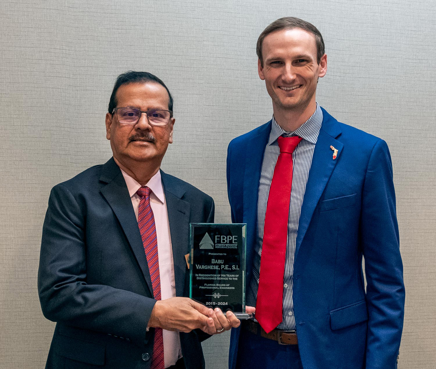 Dylan Albergo, PE, (right) FBPE Chair (2024), presents Babu Varghese, PE, SI, with a plaque honoring him for his nearly 10 years of service on the Board.